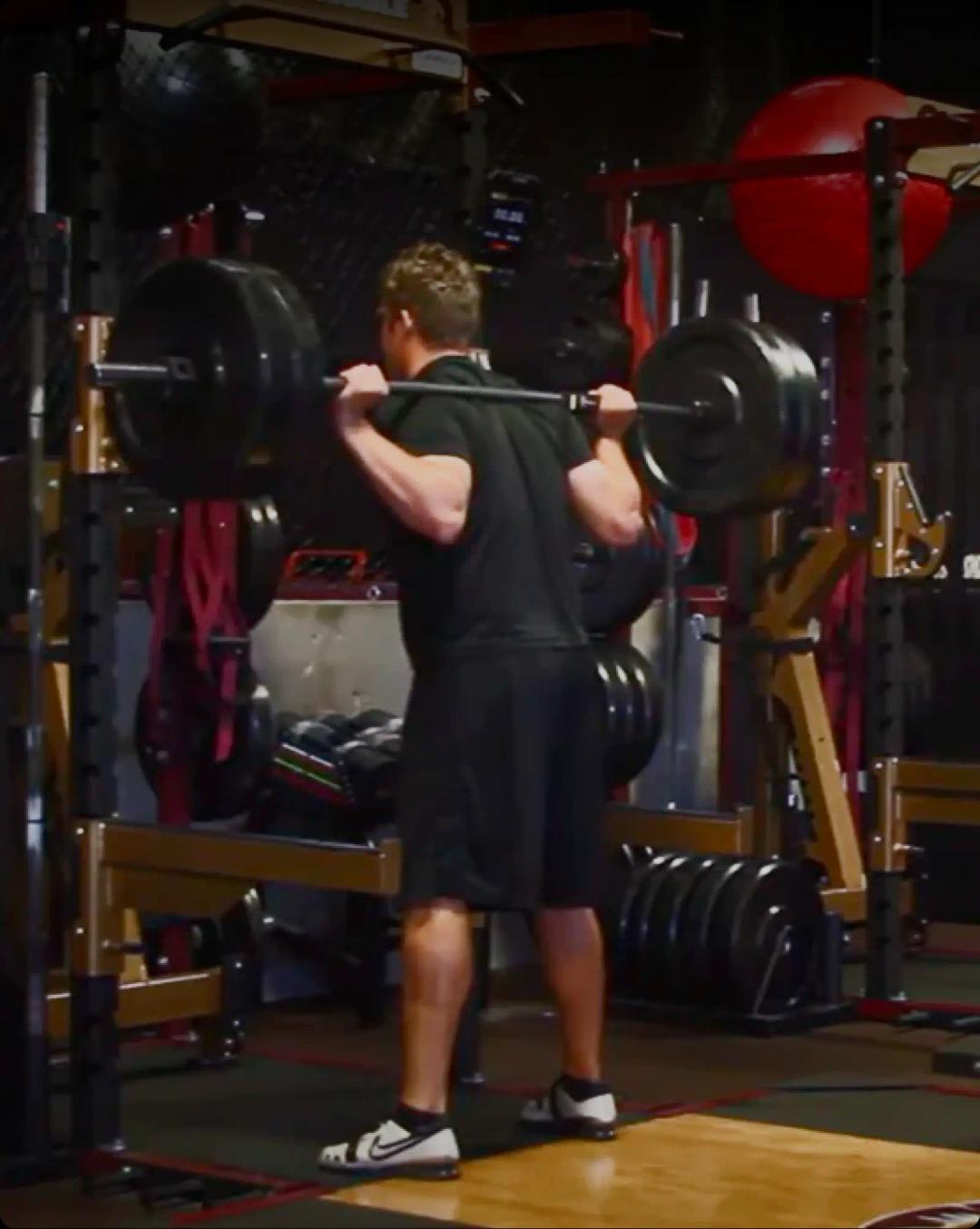 a man in black shirt and shorts weightlifting